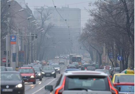 POLUARE PE ROŢI. Străzile prea aglomerate cu maşini devin o problemă tot mai serioasă pentru Oradea. Traficul rutier este principalul vinovat pentru poluarea aerului, dar şi pentru cea fonică