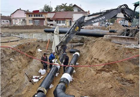 CONTRA-CRONOMETRU. Ultimele lucrări la rețelele de termoficare înaintea sezonului de încălzire au loc săptămâna aceasta în zona viitorului pasaj subteran din intersecția Bulevardului Decebal cu strada Tudor Vladimirescu. Joi, constructorii sudau rețeaua ascunși de ploaie sub umbrele mari, ca să termine la timp. „Termenul de 15 octombrie, asumat de constructor, este destul de realist. Sperăm să nu trebuiască să dăm drumul la încălzire mai repede”, spune directorul Termoficare Oradea, Călin Ungur