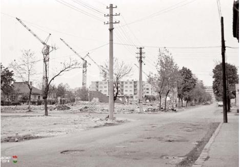FACEŢI LOC! În anii ’70-’80, au fost complet rase mai multe cartiere din Oradea, indiferent dacă locuinţele vechi erau bune sau nu. Ritmul demolărilor era alert doar dacă birocraţia se mişca suficient de repede, constructorii cerând continuu front de lucru. În 1983, strada Costache Negruzzi (foto) a fost demolată complet, macaralele "ameninţând" şi casele rămase (foto: Darabont József)