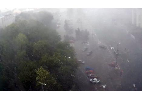 Imaginile surprinse de un webcam din zona Pieței Emanuil Gojdu arată că ploaia abundentă a redus semnificativ vizibilitatea 