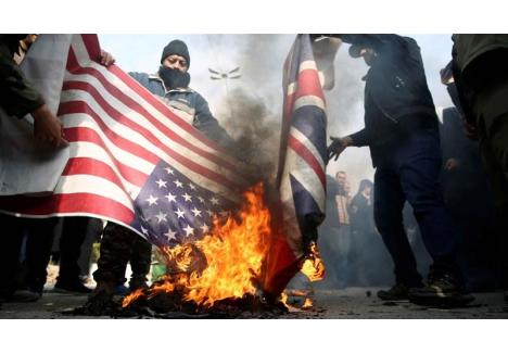 Protestatari din Iran arzând steagurile SUA şi Marii Britanii (sursa foto: www.aljazeera.com)