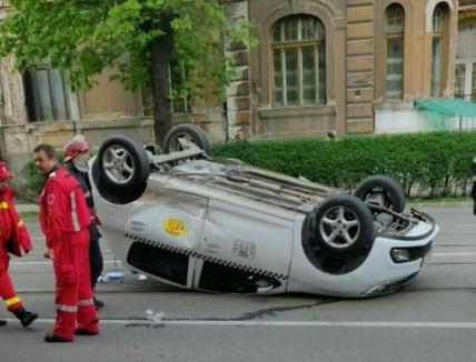 Accident în Oradea: Un taxi a ajuns cu roţile-n sus pe Republicii. Şoferul şi pasagera au fost transportaţi la spital (FOTO / VIDEO)
