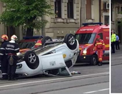 Accident în Oradea: Un taxi a ajuns cu roţile-n sus pe Republicii. Şoferul şi pasagera au fost transportaţi la spital (FOTO / VIDEO)