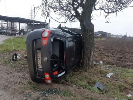 Accident lângă Sântandrei: În urma unei coliziuni, o maşină s-a răsturnat în afara şoselei, a rupt un stâlp de electricitate şi a lovit un copac (FOTO)