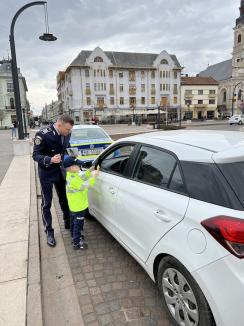 Polițistul Bogdănel în acțiune: de 1 Martie a oferit mărțișoare șoferițelor oprite în Piața Unirii din Oradea (FOTO)