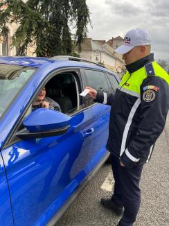 Polițistul Bogdănel în acțiune: de 1 Martie a oferit mărțișoare șoferițelor oprite în Piața Unirii din Oradea (FOTO)