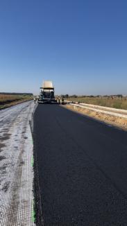 Se așterne primul strat de asfalt pe una dintre cele trei șosele de centură din Zona Metropolitană Oradea aflate în lucru (FOTO)