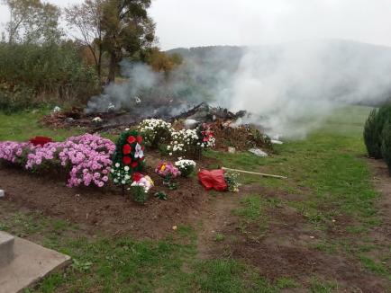 Halloween de Lugaș: În cimitirul din satul Urvind coroanele din plastic și gunoaiele sunt arse lângă morminte (FOTO)
