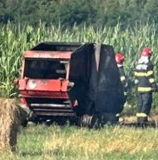 O presă de balotat a luat foc pe un teren în Săcădat (FOTO)