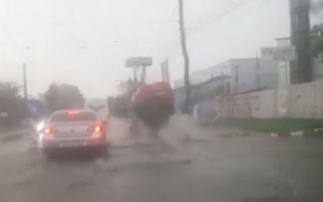 Infrastructura oraşelor româneşti: O maşină a fost aruncată doi metri în aer din cauza unei guri de canal defulat în carosabil (VIDEO)