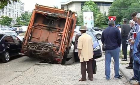 Se întâmplă în România: Maşină de gunoi "înghiţită" de asfalt în centrul Craiovei