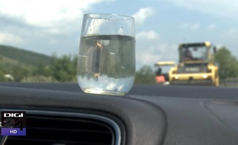 Experiment Digi24 pe drumul judeţean cu covor asfaltic proaspăt, dar inutil: Apa din paharul pus pe bordul maşinii abia s-a mişcat (VIDEO)