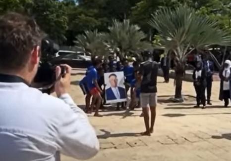 'Hakuna matata!': Ceremonial bizar pentru Klaus Iohannis în Tanzania, unde localnicii s-au aruncat în apă cu portretul lui și al soției sale (VIDEO)