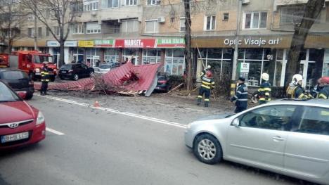 Vântul face ravagii: O parte din acoperişul unui bloc din Oradea s-a prăbuşit peste şosea şi peste maşinile parcate (FOTO / VIDEO)